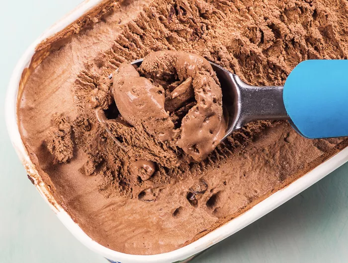 ice cream scoop in a 1.5 quart tub of chocolate ice cream
