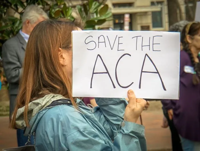 Rally in Support of the Affordable Care Act, at The White House, Washington, DC USA, carrying a sign that reads "SAVE THE ACA"