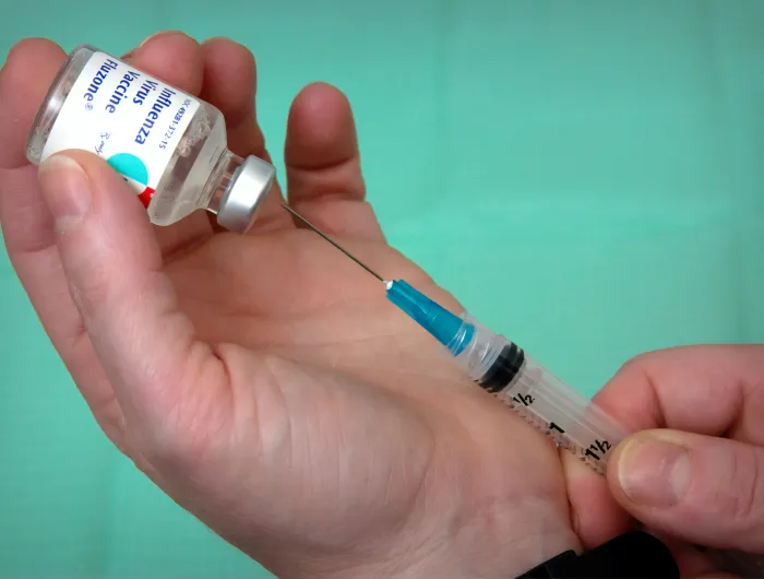 Flu vaccine being extracted from a vial