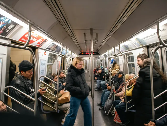 Inside a NYC subway car with prominently displayed ads