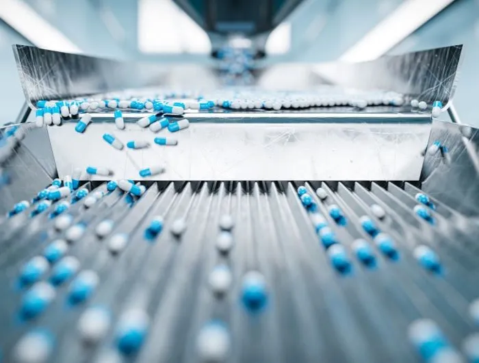 Blue and white capsules on a pharmaceutical sorting machine