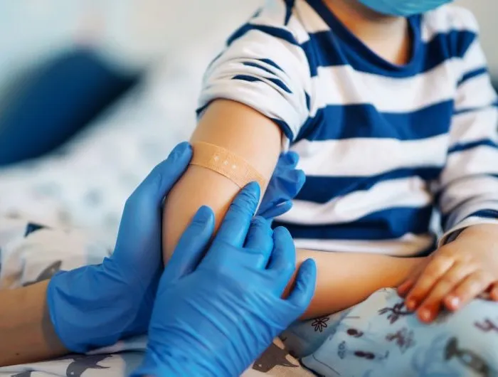 Children's doctor vaccinating little boy against common childhood diseases