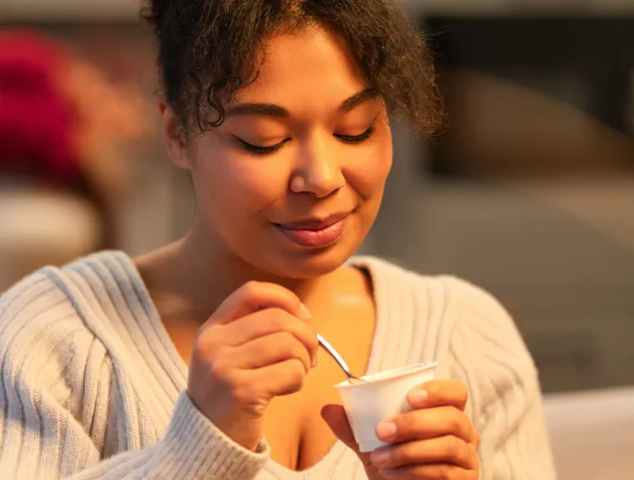 woman eating a cup of yogurt