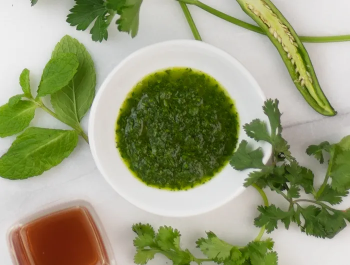 bowl of chimichurri surrounded by whole ingredients