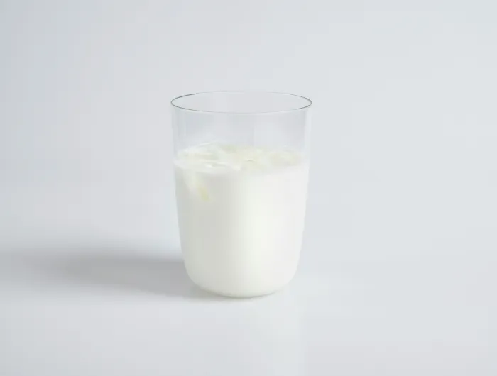 A cup of milk on a white table.