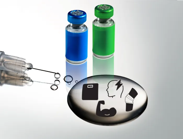 syringe with puddle of clear liquid and 2 vials