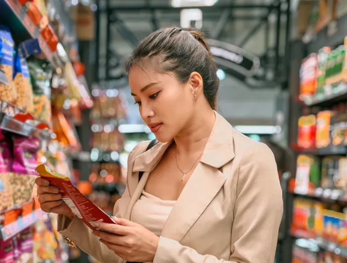 woman in grocery store looking at package of food