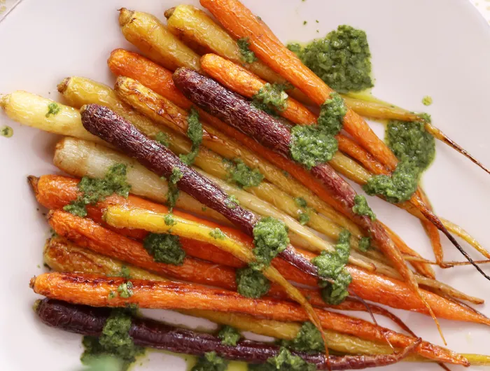 colorful roasted carrots covered in chimichurri sauce