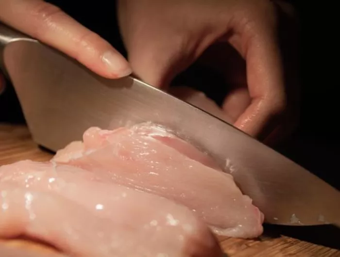 cutting raw chicken