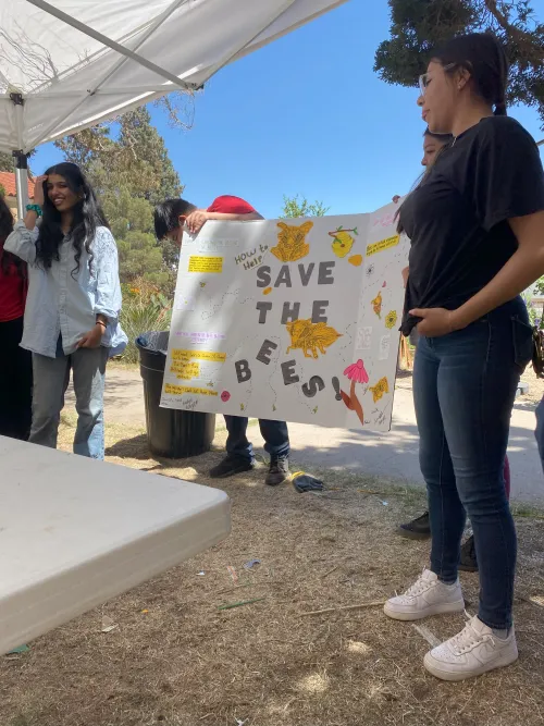 Students presenting a poster titled “save the bees."