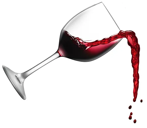 clear wine glass pouring out red wine