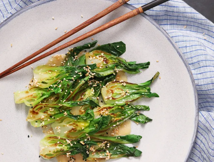 cooked bok choy with sesame sauce drizzled on top