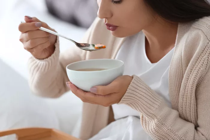 woman eating chicken soup