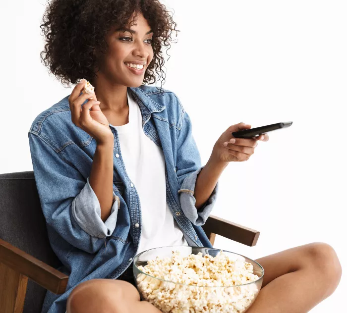 woman eating popcorn watching tv