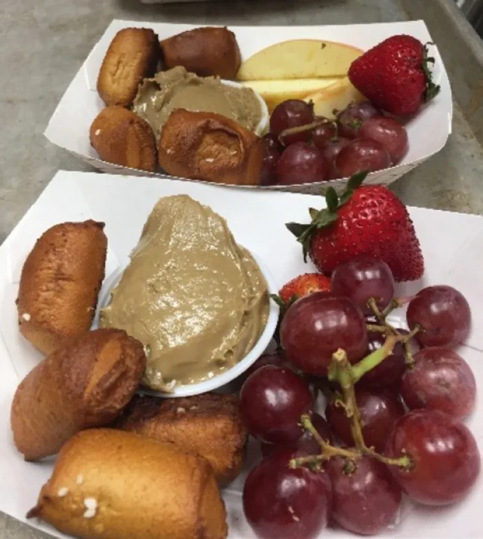 A breakfast tray: pretzel bites and sunbutter, berries, and grapes.