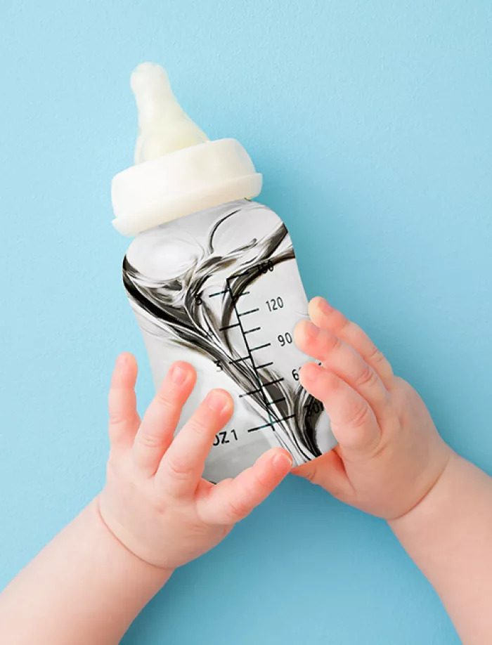 a baby's hands holding a bottle full of mercury