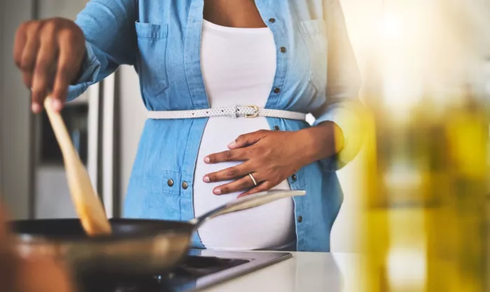 Food, cooking and pregnant woman in kitchen in home for healthy, wellness and diet meal with nutrition