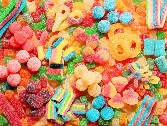 Assorted variety of sour candies includes extreme sour soft fruit chews, keys, tart candy belts and straws