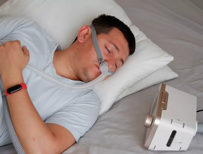 man sleeping using a CPAP machine