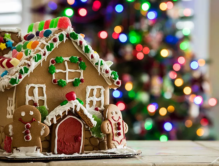 Gingerbread house with Christmas tree in background