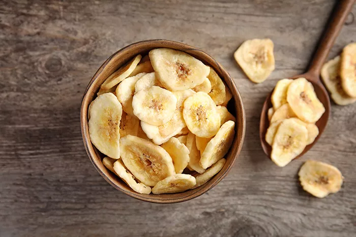 bowl of banana chips on a wood table