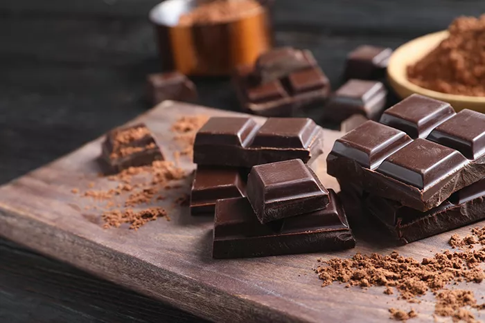 broken bar of chocolate on wood cutting board
