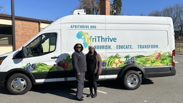 AfriThrive partners standing with an AfriThrive truck
