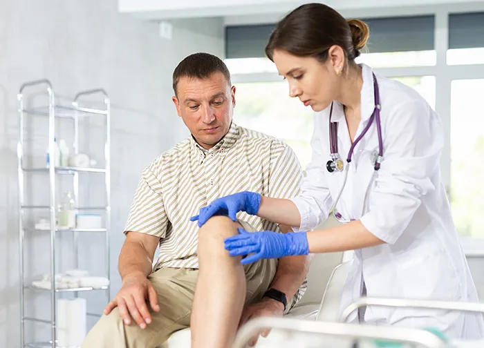 doctor examining a man's knee