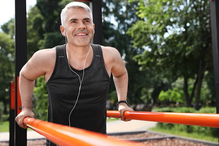 man using parallel bars for exercise outside