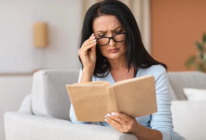 woman reading a book while wearing glasses