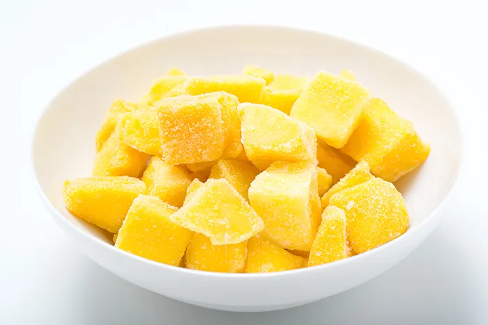 white bowl with frozen mango chunks