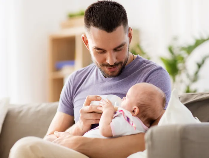 man bottle feeding a baby