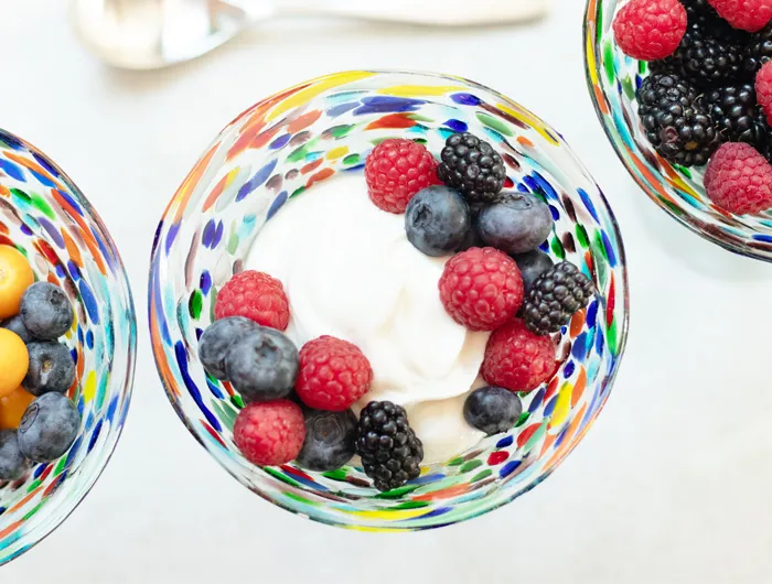 colorful glass bowl filled with yogurt and berries