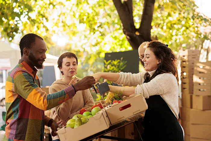 woman selling fresh fruit at outdoor farmers market