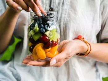 woman holding a jar of fruit