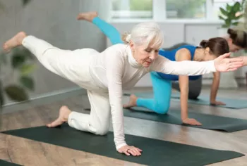 Women in exercise class doing a "bird dog"