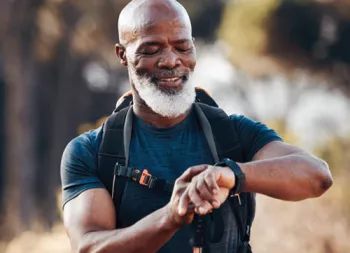 man walking outside and checking his watch