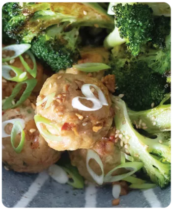 close up of broccoli and poultry meatballs with spices