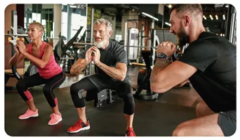 3 people doing squats in a gym