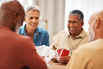 4 older men playing cards