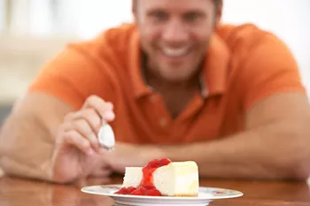 man about to take a spoonful of cheesecake