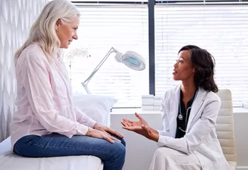 doctor speaking to older woman in doctors office