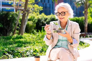 Woman eating a salad in the park