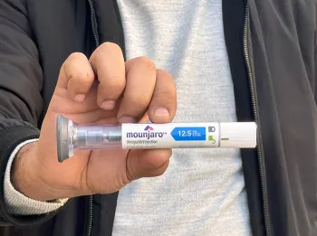 person holding a mounjaro pen up close to the camera
