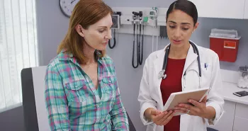 doctor showing female patient something on a chart
