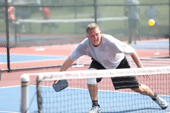 older man playing pickleball