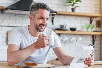 man holding coffee cup in kitchen