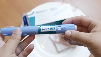 hands holding an Ozempic injector pen