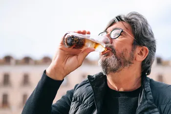 man drinking a glass of cola