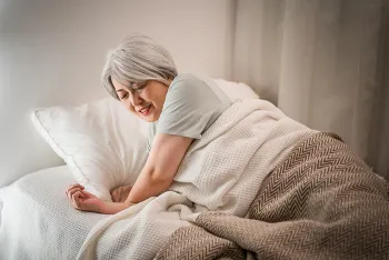 middle aged woman laying down in bed